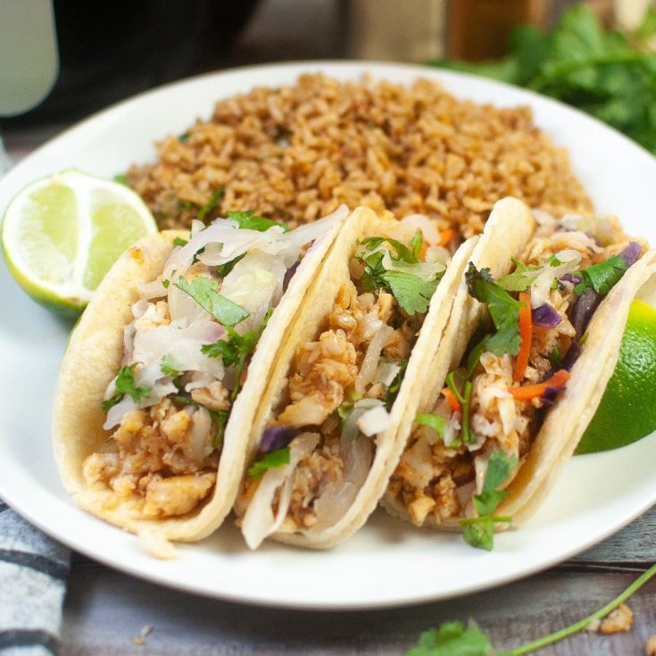 Thai chicken tacos on a plate with rice served alongside air fryer Fish Tacos.