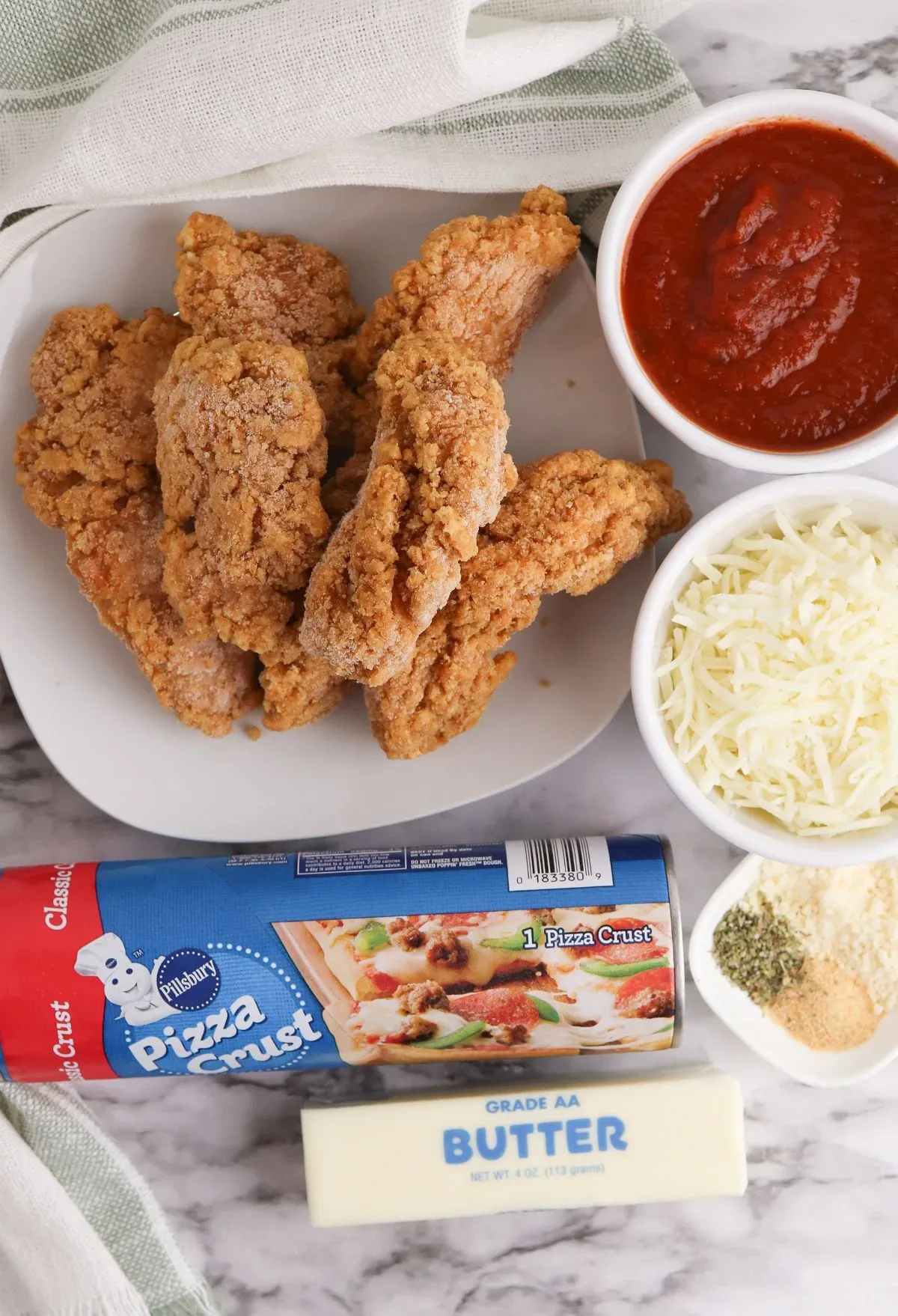 Chicken wings with sauce and cheese on a marble table.