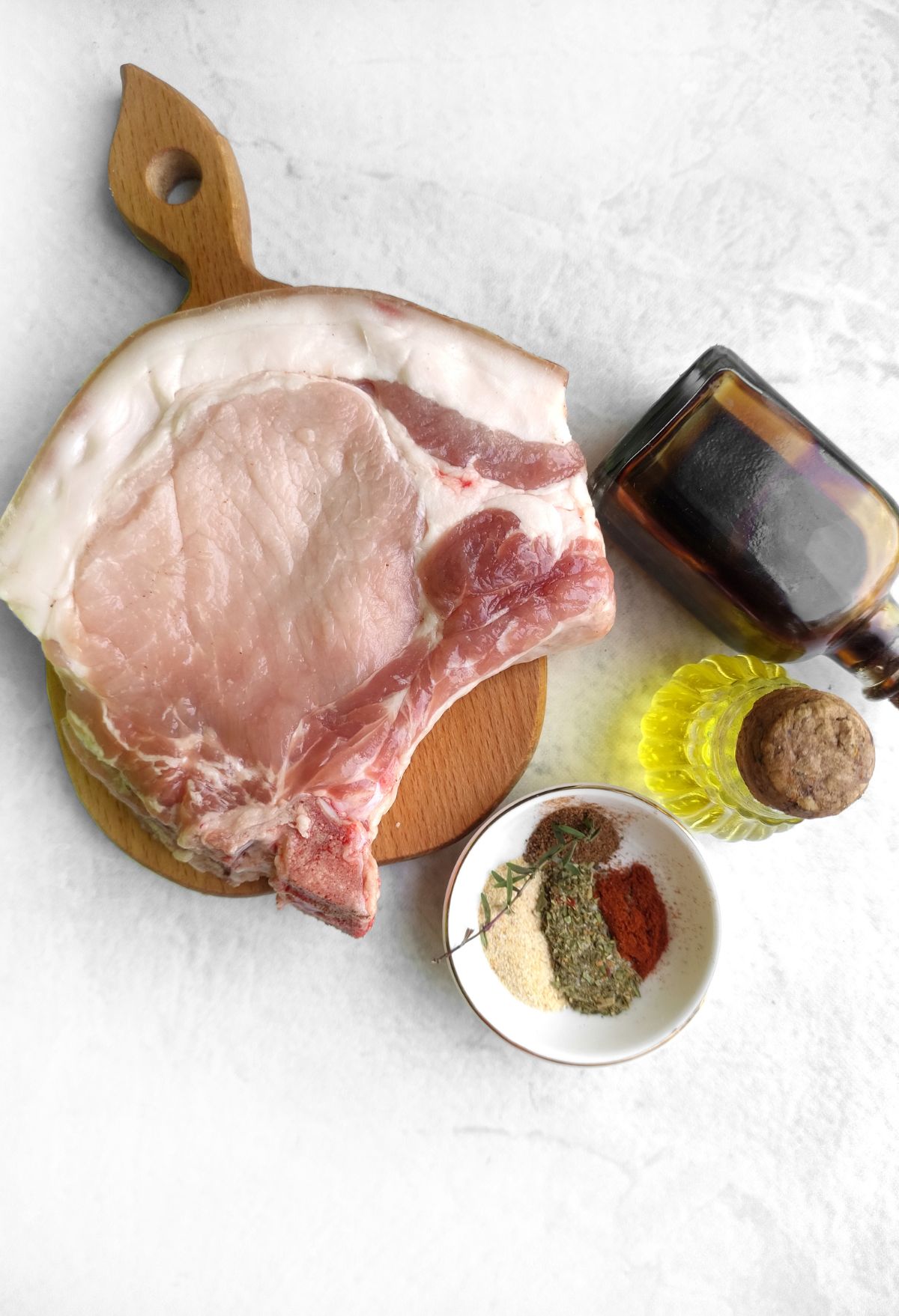 Grilled pork chops with spices on a cutting board.