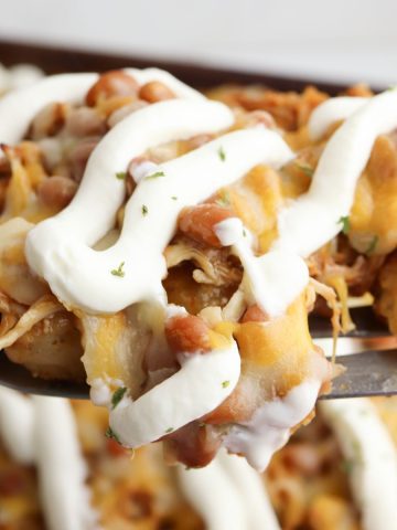 Tater Tot Nachos piled high with cheese and sour cream.