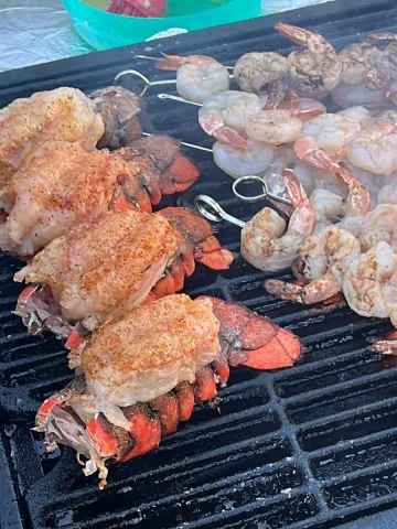 A grill with shrimp and lobster on it.