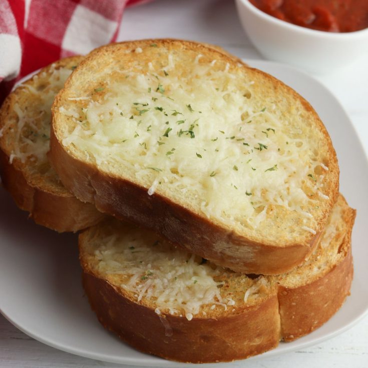 Three slices of bread with cheese and sauce on a plate.