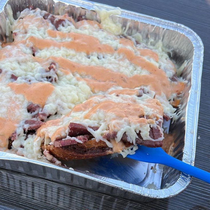 A tray of food with cheese and meat in it.